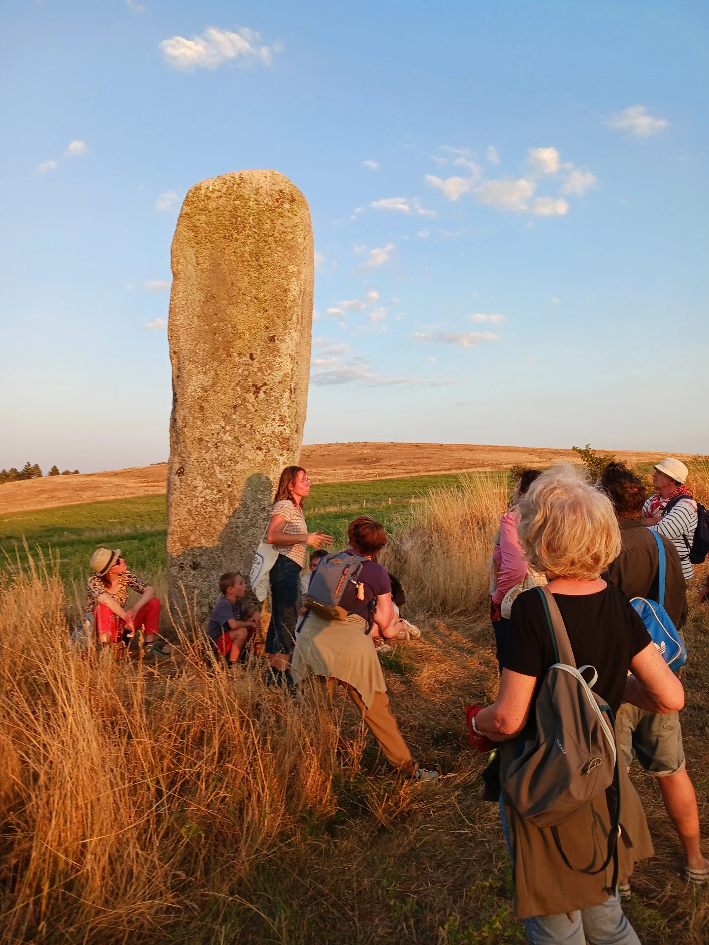 Mariette Emile, guide conférencière devant un menhir